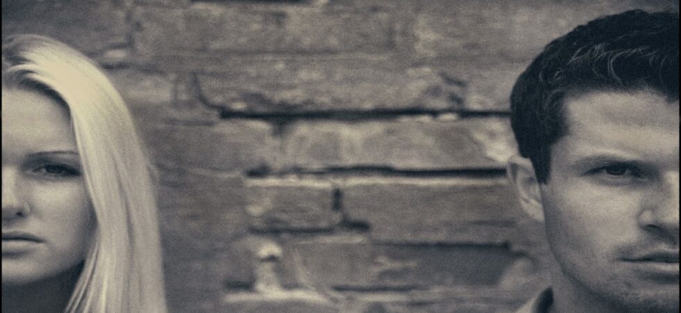 Fights in relationship: half faces of a couple at two opposite ends of the image